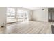 An open living space boasts luxury vinyl flooring, a large picture window and access to other rooms at 5210 Ashbourne Ln, Indianapolis, IN 46226