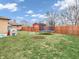 The backyard with a trampoline, a play house, a stone fire pit and a wood fence at 606 Memorial Dr, Beech Grove, IN 46107