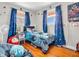 Spacious bedroom features hardwood floors, windows for natural light, and blue curtains at 606 Memorial Dr, Beech Grove, IN 46107
