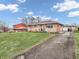 Charming brick home with a well-manicured lawn, a long driveway and mature trees at 606 Memorial Dr, Beech Grove, IN 46107