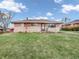 Charming single-story brick home featuring a well-manicured front yard, a red brick chimney, and an American flag at 606 Memorial Dr, Beech Grove, IN 46107