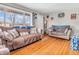 Bright living room featuring hardwood floors, neutral-toned sofas, and a large picture window for plenty of natural light at 606 Memorial Dr, Beech Grove, IN 46107