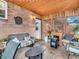 Cozy sunroom features brick and wood walls, wood paneled ceiling with lights, and comfortable seating at 606 Memorial Dr, Beech Grove, IN 46107