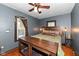 Cozy bedroom with hardwood floors, ceiling fan, and a dog crate nightstand at 6179 Norwaldo Ave, Indianapolis, IN 46220