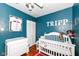 Cozy Bedroom with blue walls, a white crib, changing table, and sporty baseball decor at 6179 Norwaldo Ave, Indianapolis, IN 46220