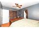 Relaxing bedroom with hardwood floors, ceiling fan, and custom closet doors at 6179 Norwaldo Ave, Indianapolis, IN 46220
