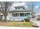 Charming blue two-story home with a welcoming front porch and vibrant yellow accents at 6179 Norwaldo Ave, Indianapolis, IN 46220