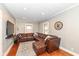 Comfortable living room with leather sectional, hardwood floors, and natural lighting at 6179 Norwaldo Ave, Indianapolis, IN 46220