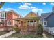 Quaint yellow house with a welcoming porch, set between a red brick building and blue home at 645 E 9Th St, Indianapolis, IN 46202