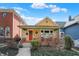 Charming yellow home features a cozy front porch, red door, and well-maintained landscaping at 645 E 9Th St, Indianapolis, IN 46202
