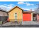 Detached garage with a striking red door and a charming yellow exterior, adding character to the property at 645 E 9Th St, Indianapolis, IN 46202