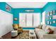 Bright living room with vibrant turquoise walls, white trim, and stylish modern furniture at 645 E 9Th St, Indianapolis, IN 46202