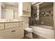 Well-lit bathroom with a vanity and enclosed shower-tub combo, featuring neutral tile work and ample storage at 6560 Dawson Lake Dr, Indianapolis, IN 46220