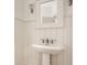 Bright bathroom featuring a pedestal sink, modern fixtures, and wood paneled walls at 6560 Dawson Lake Dr, Indianapolis, IN 46220