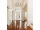 Elegant foyer with hardwood floors, chandelier, and leaded glass windows flanking the front door at 6560 Dawson Lake Dr, Indianapolis, IN 46220