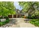 View of a home's three-car garage and stone brick facade and manicured front yard at 6560 Dawson Lake Dr, Indianapolis, IN 46220
