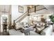 Bright living room featuring a staircase, chandelier, neutral furniture, and open access to the kitchen at 6560 Dawson Lake Dr, Indianapolis, IN 46220