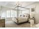 Bright main bedroom with a four-poster bed and a chandelier, complemented by natural light from shuttered windows at 6560 Dawson Lake Dr, Indianapolis, IN 46220