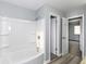 Well-lit bathroom features a shower and tub combo with wooden floors and gray walls at 7322 S Sherman Dr, Indianapolis, IN 46237
