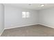 Well-lit bedroom showcasing neutral walls, soft carpeting, and a window at 7322 S Sherman Dr, Indianapolis, IN 46237