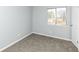 This bedroom offers neutral walls, plush carpeting, and a window with natural light at 7322 S Sherman Dr, Indianapolis, IN 46237