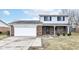 Charming two-story home featuring a brick facade, attached garage, and well-maintained front yard at 7322 S Sherman Dr, Indianapolis, IN 46237