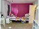 Bedroom with bright pink accent wall, trundle bed, ceiling fan, desk, and closet at 8360 S Evening Dr, Pendleton, IN 46064