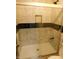 Enclosed shower featuring tiled walls, black accent stripe, and glass sliding door at 8940 Black Hawk Ln, Indianapolis, IN 46234