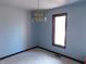 A bedroom with light blue walls, white carpeting, a window, and a chandelier light fixture at 8940 Black Hawk Ln, Indianapolis, IN 46234