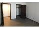 Spacious bedroom with two entry doors, wood floor, and an open closet with shelf and hanging rod at 8940 Black Hawk Ln, Indianapolis, IN 46234