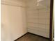 A closet with white walls, a light and dark wood frame, and multiple white shelves for storage at 8940 Black Hawk Ln, Indianapolis, IN 46234