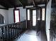 A foyer with dark wood railings and trim, stained wood doors, and a bright window at 8940 Black Hawk Ln, Indianapolis, IN 46234