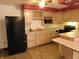A kitchen with light wood cabinets, black appliances, and a wine rack above the sink at 8940 Black Hawk Ln, Indianapolis, IN 46234