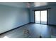 Open living area with sliding glass doors, fan, and new floors at 8940 Black Hawk Ln, Indianapolis, IN 46234