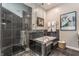 Modern bathroom with sleek, dark tiling, a glass-enclosed shower, and a soaking tub, creating a spa-like experience at 932 N Broadway St # 1, Indianapolis, IN 46202