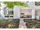 Modern townhome featuring a gray brick facade, manicured lawn and inviting covered front porch seating area at 932 N Broadway St # 1, Indianapolis, IN 46202
