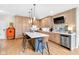 Bright kitchen with light wood cabinets, quartz countertops, stainless appliances, and an island with bar stool seating at 932 N Broadway St # 1, Indianapolis, IN 46202