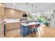 Open concept kitchen with island seating, stainless appliances, and a view into the bright, oversized living room at 932 N Broadway St # 1, Indianapolis, IN 46202