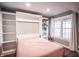 Bright bedroom featuring a built-in murphy bed, shelving, and a window with natural light at 9505 Bay Vista W Dr, Indianapolis, IN 46250