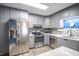 Renovated kitchen with gray cabinets, quartz countertops, stainless steel appliances, and tile backsplash at 9505 Bay Vista W Dr, Indianapolis, IN 46250