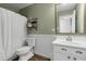 Bright bathroom featuring a white shower curtain, toilet, and vanity with decorative mirror and shelves at 10326 Haag Dr, Brownsburg, IN 46112
