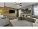 Spacious living room with hardwood floors, a ceiling fan, and a wood accent wall at 10326 Haag Dr, Brownsburg, IN 46112