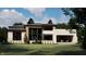Backyard view of modern house showcasing a manicured lawn and covered outdoor living area at 10440 Somerford Rdg, Zionsville, IN 46077