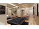 The pool table stands ready for a game night in the living area with bar, wine storage, and sleek staircase at 10440 Somerford Rdg, Zionsville, IN 46077
