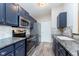 Well-lit kitchen with stainless steel appliances, gray cabinets, granite counters and tile backsplash at 1057 Timber Creek Dr # 12, Carmel, IN 46032