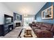 Cozy living room featuring a fireplace, brown leather sofa, and sliding doors to the balcony at 1057 Timber Creek Dr # 12, Carmel, IN 46032