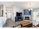Sunlit living room with a fireplace, gray wood floors, and access to outdoor balcony at 1057 Timber Creek Dr # 12, Carmel, IN 46032