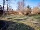 Landscaped backyard with mature trees and a stone border provides privacy and natural beauty at 10831 Canoe Ct, Indianapolis, IN 46236