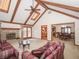 Bright living room featuring a stone fireplace, beamed ceilings, and access to the outdoor deck at 10831 Canoe Ct, Indianapolis, IN 46236