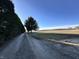 Gravel driveway with tree lined border leading to fields under bright sunny sky at 1125 S Buffalo Hill Rd, Martinsville, IN 46151